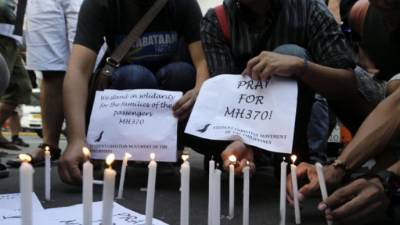 Estudiantes filipinos encienden velas durante una jornada de rezos por los tripulantes del avión de Malaysia Airlines que con 239 personas a bordo desapareció el 8 de marzo, en Manila (Filipinas) hoy, jueves 13 de marzo de 2014. EFE