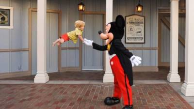 El pequeño Will fue captado por su padre 'volando' mientras saluda a Mickey Mouse.