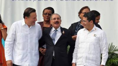 Los presidentes de Panamá, Juan Carlos Varela; de República Dominicana, Danilo Medina y de Honduras, Juan Orlando Hernández, bromean hoy en La Habana, Cuba, durante la foto oficial de los jefes de estado participantes en la VII Cumbre de la Asociación de Estados del Caribe (AEC). EFE