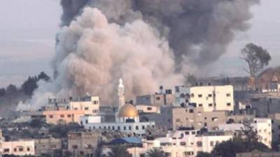 Buildings destroyed by Israeli strikes are reflected on a shop window, in Gaza City, on May 25, 2021. - A ceasefire was reached late last week after 11 days of deadly violence between Israel and the Hamas movement which runs Gaza, stopping Israel's devastating bombardment on the overcrowded Palestinian coastal enclave which, according to the Gaza health ministry, killed 248 Palestinians, including 66 children, and wounded more than 1,900 people. Meanwhile, rockets from Gaza claimed 12 lives in Israel, including one child and an Israeli soldier. (Photo by MOHAMMED ABED / AFP)