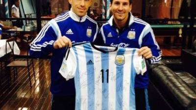 Maxi Rodríguez y Lionel Messi posan con la camisa de la albiceleste autografiada.