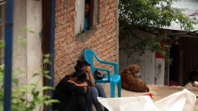 Una hija del fallecido llora afuera de la vivienda al darse cuenta de la muerte de su padre.