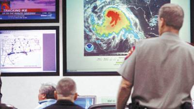 Workers in the state emergency operations center look at weather imagery Friday, Sept. 12, 2008, in Austin, Texas, as they anticipate landfall of Hurricane Ike on the Texas Gulf coast. Hurricane Ike, a colossal storm nearly as big as Texas itself, began battering the coast Friday, threatening to obliterate waterfront towns and give the skyscrapers, refineries and docks of the nation's fourth-largest city their worst pounding in a generation. (AP Photo/Harry Cabluck)