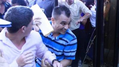 Algunos hondureños ante la desesperación de ingresar a la Feria del Empleo terminaron quebrando una de las puerta de vidrio de Expocentro en San Pedro Sula.