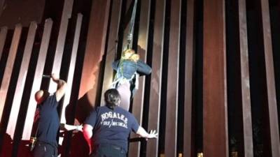 El departamento de Bomberos de Nogales tuvo que auxiliar a la mujer que quedó colgada del muro en la frontera entre EUA y México.