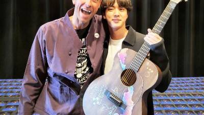 Chris Martin, líder de la banda Coldplay, junto a Jin, miembro del exitoso grupo coreano BTS.