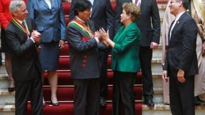 Morales saluda a la presidenta brasileña Dilma Rousseff en la foto oficial de la toma de posesión donde también aparece el mandatario ecuatoriano Rafael Correa junto a otros invitados.