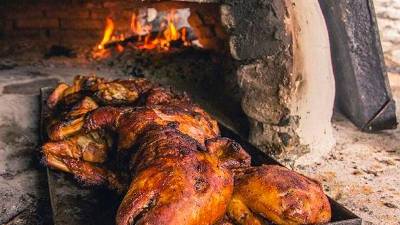 Hondureña conquista paladar de sampedranos con lechones horneados en Copán