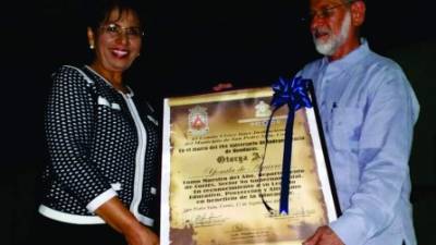 Marco Rietti entrega el reconocimiento a la maestra Reina Yomila de Aguirre.