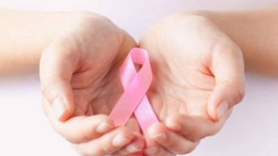 holding pink breast cancer awareness ribbon