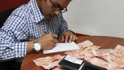 Un joven hace cuentas en una libreta para formular su presupuesto del año 2016. Foto: José Cantarero