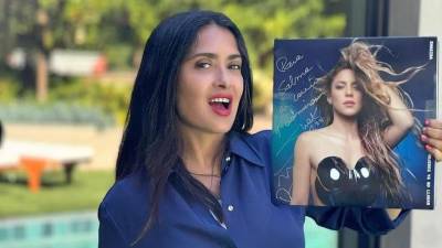 Salma Hayek posando feliz con el disco de vinilo de Shakira.