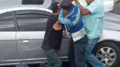 Un policía de Tránsito interviene entre el taxista y el conductor que peleaban en el bulevar Morazán.