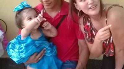 La niña Alison Gonzales en brazos de su papá.