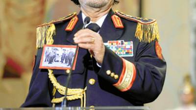 (FILES) -- A file picture taken on June 10, 2009 shows Libya's leader Moamer Kadhafi standing during a press conference at Rome's Quirinale presidential palace in Italy. AFP PHOTO / FILIPPO MONTEFORTE