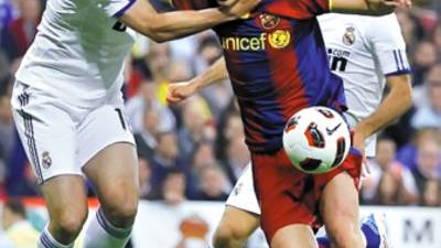 Real Madrid's Raul Albiol (L) grabs Barcelona's David Villa during their Spanish first division soccer match at Santiago Bernabeu stadium in Madrid April 16, 2011. REUTERS/Juan Medina (SPAIN - Tags: SPORT SOCCER)