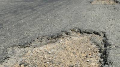 La gran cantidad de hoyos en la vía ponen en riesgo a los conductores.
