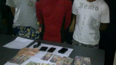 Los tres detenidos con las evidencias encontradas al momento de su captura.
