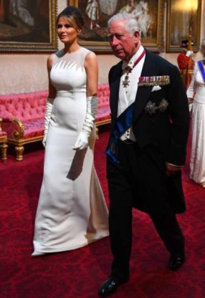 Britain's Prince Charles, Prince of Wales (R) walks with US First Lady Melania Trump as they arrive through the East Gallery during a State Banquet in the ballroom at Buckingham Palace in central London on June 3, 2019, on the first day of the US president and First Lady's three-day State Visit to the UK. - Britain rolled out the red carpet for US President Donald Trump on June 3 as he arrived in Britain for a state visit already overshadowed by his outspoken remarks on Brexit. (Photo by Victoria Jones / POOL / AFP)