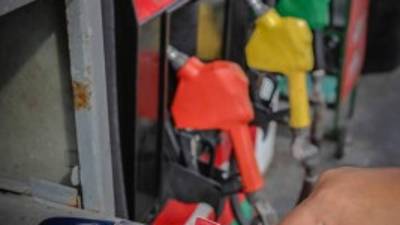 Un bombero pasa la tarjeta para realizar el cobro a uno de los clientes en una gasolinera sampedrana.