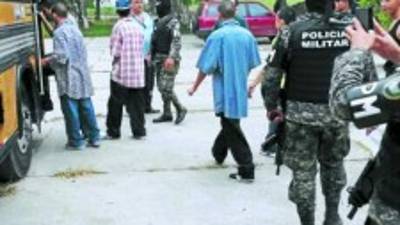 Los menores al momento de subir al autobús resguardado por los agentes.