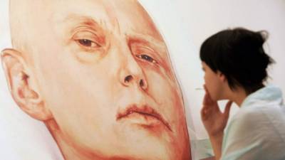Una joven examina la pintura del exespía ruso Alexandre Litvinenko, realizada en 2006 y que lo representa en su lecho de hospital. La obra se exhibe en Moscú.