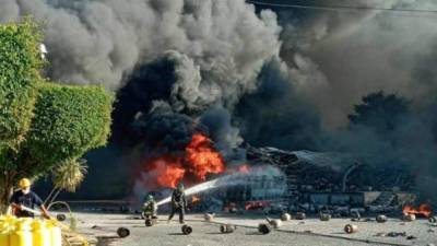 Los bomberos luchaban por contener las llamas y evitar mayores daños en los alrededores de la planta.