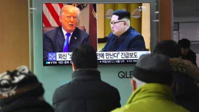 Una pantalla de televisión muestra un informe con imágenes del presidente estadounidense Donald Trump (L) y el líder norcoreano Kim Jong-un en una estación de tren en Seúl. AFP