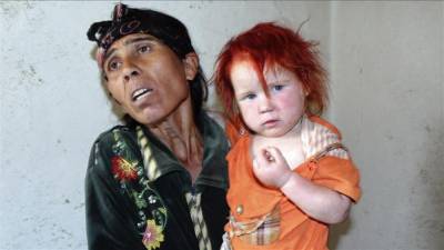 La supuesta madre de la niña conocida como el 'Ángel rubio', coge hoy a otra de sus hijas en su domicilio de Nikolaevo (Bulgaria). EFE