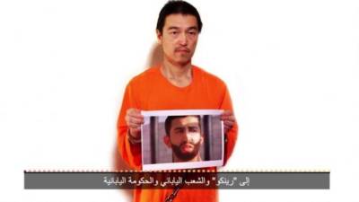 El periodista japonés secuestrado por Isis muestra la foto del piloto jordano que los yihadistas amenazan con decapitar.
