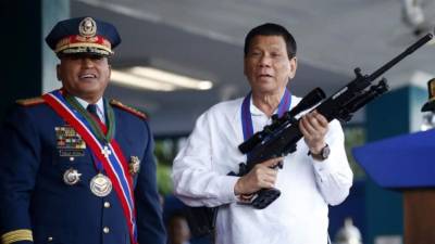 El presidente de Filipinas, Rodrigo Duderte, carga un fusil en un acto político.