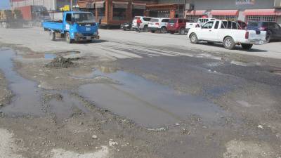 La calle al muelle de cabotaje urge ser reparada. La alcaldía pide sea intervenida lo antes posible, ya que turistas que van a Islas de la Bahía se quejan por el mal estado de la vía.