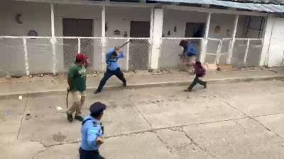 Imagen muestra el momento en que uno de los agresores lanza una piedra sobre la humanidad del agente de la Policía Nacional, en La Paz (Honduras).