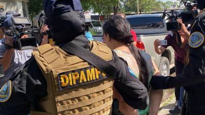 Fotografía de archivo que muestra a miembros de la Dipampco trasladando a una mujer detenida.