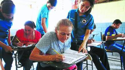 Estudiantes enseñan a leer y escribir a personas adultas como parte de su trabajo social.