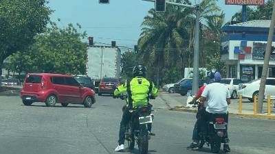 Dos hombres circulan en una misma motocicleta por una de las calles de San Pedro Sula.