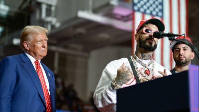 El expresidente Donald Trump junto a los reguetoneros puertorriqueños Anuel AA y Justin Quiles.