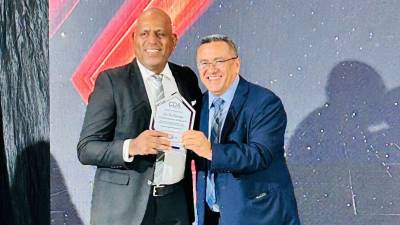 El periodista coloneño José Luis Barralaga recibe su placa de reconocimiento de manos de Rosel Matute.