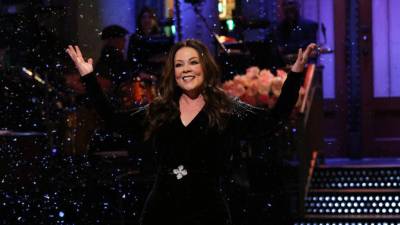 Melissa McCarthy trajo sus dotes de comedia y sirvió como inspiración en su regreso a Saturday Night Live el 6 de diciembre. La actriz y comediante mostró sus curvas con un mono de terciopelo negro cuando regresó para su sexto trabajo como presentadora de SNL.