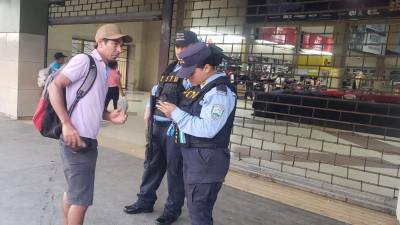Agentes interceptando a un ciudadano para validar sus documentos personales al interior de la Terminal de Buses.