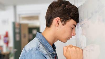 Un estudiante pasa a la pizarra a resolver una ecuación matemática.