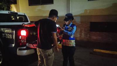 Una agente de la Dirección Nacional de Vialidad y Transporte le realiza una prueba de alcoholemia a un conductor durante un operativo de rutina.