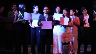Los alumnos de la academia posan con su diploma por culminar con éxito su período anual de educación musical.