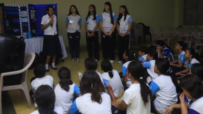 Un grupo de estudiantes de octavo grado de la María Mazzarello realizando una presentación de su proyecto a otros alumnos de la institución.