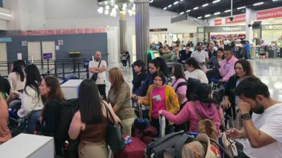 Pasajeros se forman en fila para ser atendidos en los mostradores de la erolínea tras la cancelación del vuelo.