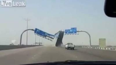 Momento en que el camión pasa debajo del anuncio y choca contra él.