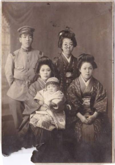 Después de que Hideo fue llamado a los militares en 1937 durante la Segunda Guerra Sino-Japonesa, Kane se involucró más en el negocio familiar, puliendo arroz y haciendo pasteles de arroz mientras cuidaba a sus hijos, así como a la suegra de Kane.<br/><br/>El primer hijo de Kane, Nobuo, también se unió al ejército en 1943 y fue retenido en cautiverio por la Unión Soviética después de la Segunda Guerra Mundial, regresando a Japón en 1947.<br/><br/>Foto: De izquierda a derecha: Hideo Tanaka, Kane Tanaka, Nobuo Tanaka, Tsuruko Kunimasa, Toyoko Nakamura.