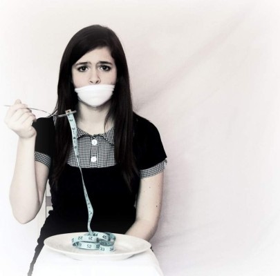 Young girl watching a fishbowl --- Image by © Royalty-Free/Corbis