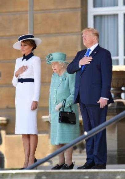 Britain's Queen Elizabeth II (C) stands with US President Donald Trump (R) and US First Lady Melania Trump (L) as they listen to the US national anthem during a welcome ceremony at Buckingham Palace in central London on June 3, 2019, on the first day of the US president and First Lady's three-day State Visit to the UK. - Britain rolled out the red carpet for US President Donald Trump on June 3 as he arrived in Britain for a state visit already overshadowed by his outspoken remarks on Brexit. (Photo by TOBY MELVILLE / POOL / AFP)
