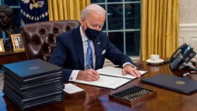 El presidente Joe Biden firma órdenes ejecutivas durante sus primeros minutos en la Oficina Oval, en la Casa Blanca. EFE